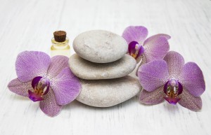 Orchids and massage stones on a wooden background