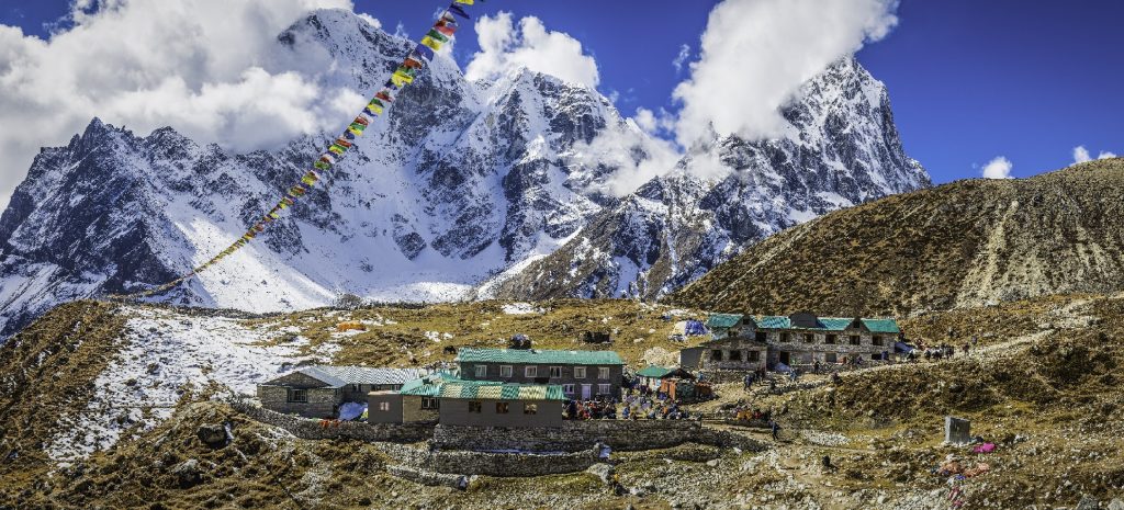 Prayer flags flying over Sherpa teahouse Khumbu mountains Himalayas Nepal