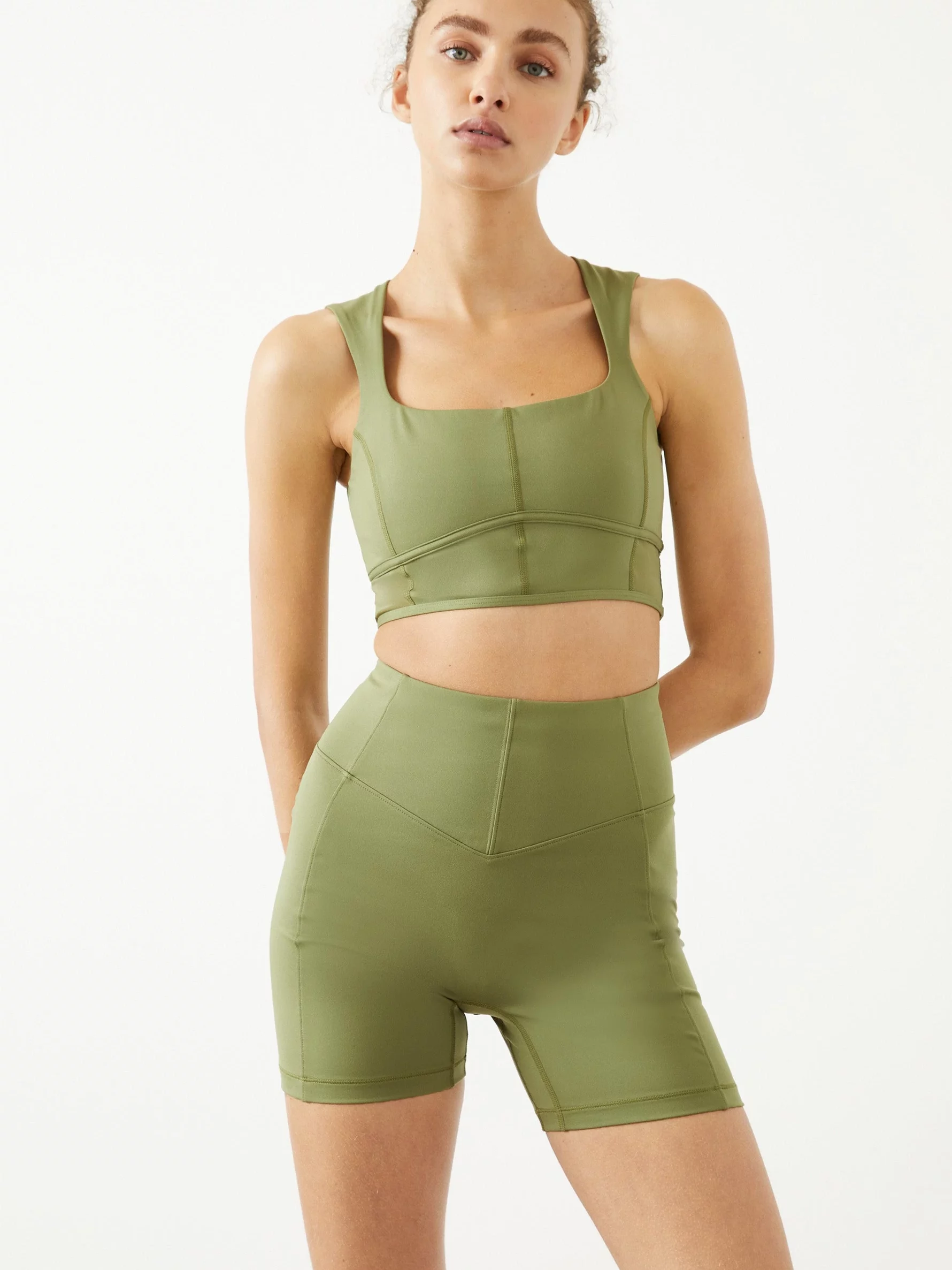 Light green athletic set. Top is squareneck and cropped with seams for decoration. The bottoms are biker shorts with the same decorative seams.
